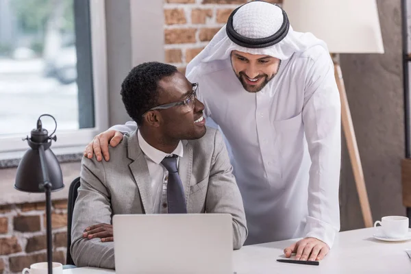 Афро-американських бізнесмен, дивлячись на арабській партнера в офісі — стокове фото