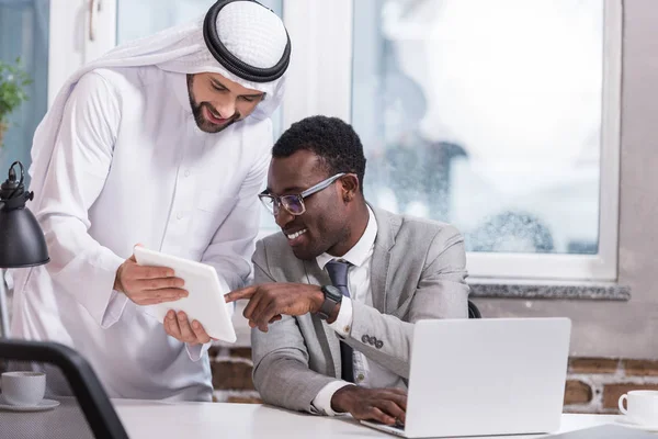 Empresários multiculturais usando tablet digital no escritório moderno — Fotografia de Stock