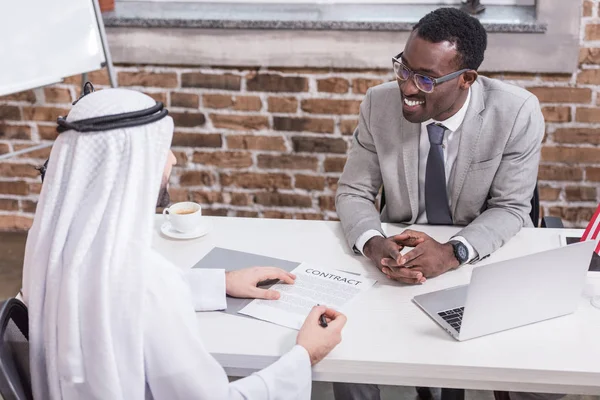 Arabo uomo d'affari firma contratto alla scrivania dell'ufficio — Foto stock