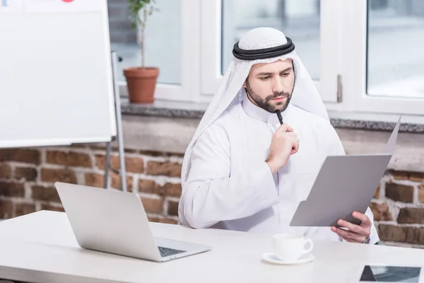 Arabe homme d'affaires regardant dossier et penser au bureau — Photo de stock