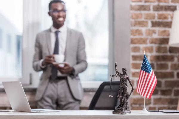 Ufficio scrivania e oggetti con afro americano uomo d'affari su sfondo — Foto stock