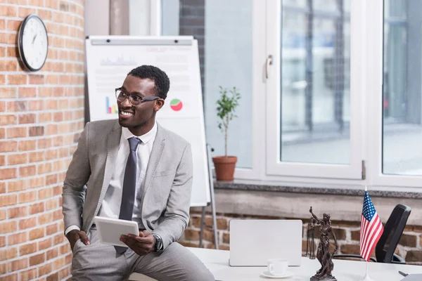 Homme d'affaires afro-américain tenant une tablette numérique avec la main dans la poche — Photo de stock