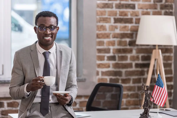 Uomo d'affari afroamericano che beve caffè in ufficio — Foto stock