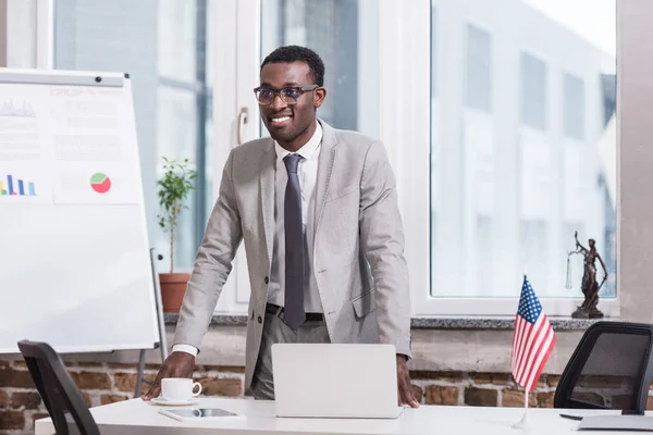 Afrikanischer amerikanischer Geschäftsmann lächelt in modernem Büro — Stockfoto