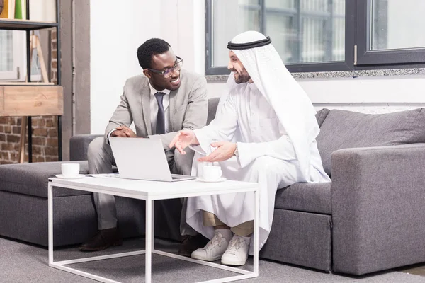 Des hommes d'affaires multiethniques discutent dans un bureau moderne — Photo de stock