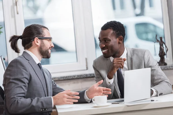 Sonrientes empresarios multiétnicos que se reúnen en el cargo - foto de stock