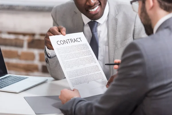 Обрізаний вид афроамериканського бізнесмена, що показує контракт з партнером — стокове фото