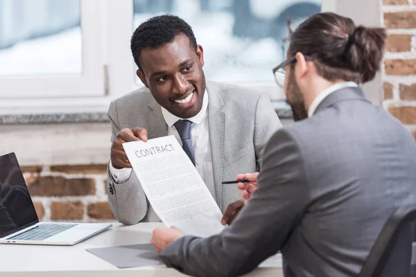 Hommes d'affaires multiethniques signant un contrat au bureau — Photo de stock