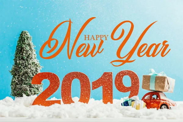 Grandi numeri rossi 2019 con macchinina, regali e albero di Natale sulla neve con scritte 