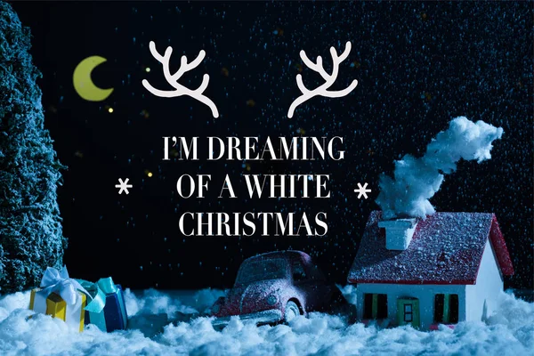 Nahaufnahme von Spielzeugauto mit Weihnachtsgeschenken und schneebedecktem Haus in der Nacht, mit 