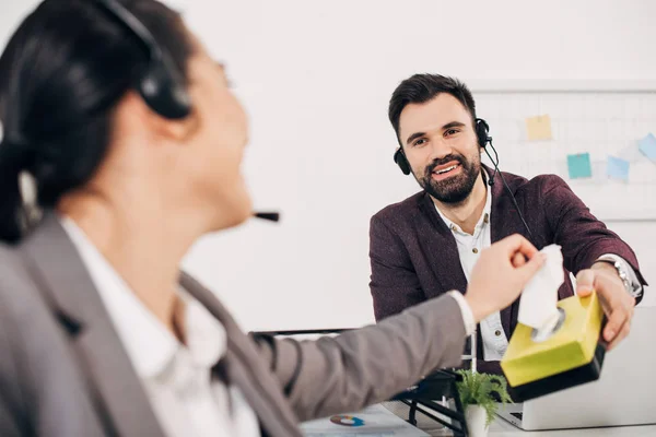 Sorrindo operador de call center dando guardanapos para colega de trabalho no escritório — Fotografia de Stock