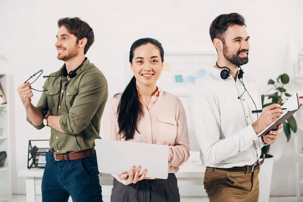 Happy office managers smiling and standing in office — Stock Photo