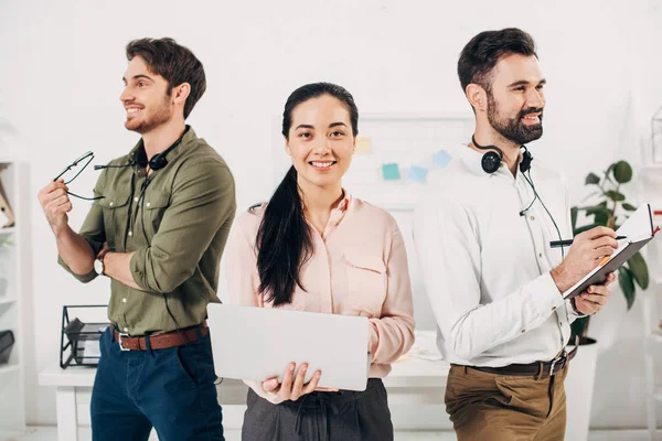 Felice ufficio manager sorridente e in piedi in ufficio — Foto stock