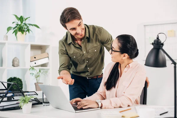 Handsome call center operator looking to pretty coworker in office — Stock Photo