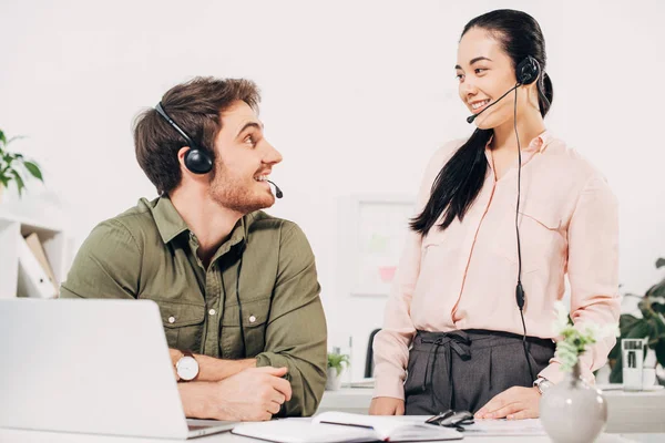 Lächelnder Callcenter-Betreiber schaut sich im Büro an — Stockfoto