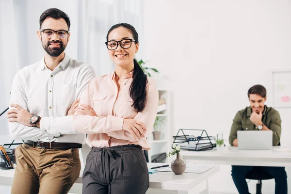 Directeurs de bureau avec les bras croisés souriant et regardant caméra dans le bureau — Photo de stock