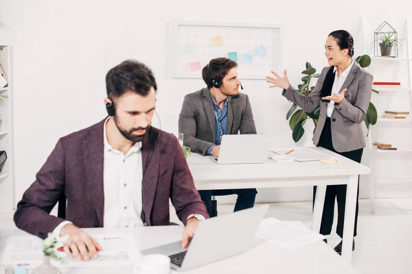 Jefe enojado gritando al operador en auriculares en la oficina moderna - foto de stock