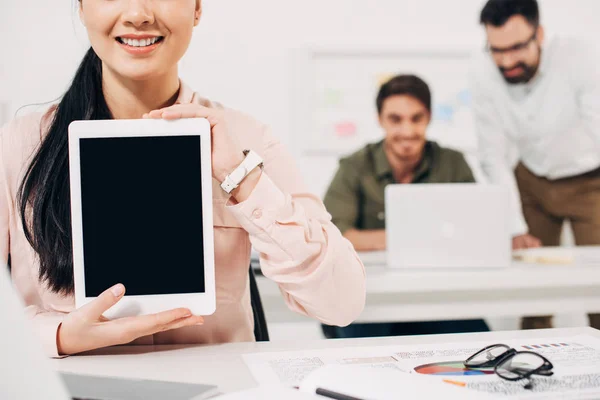 Vue recadrée de la femme tenant tablette numérique avec écran blanc dans le bureau — Photo de stock