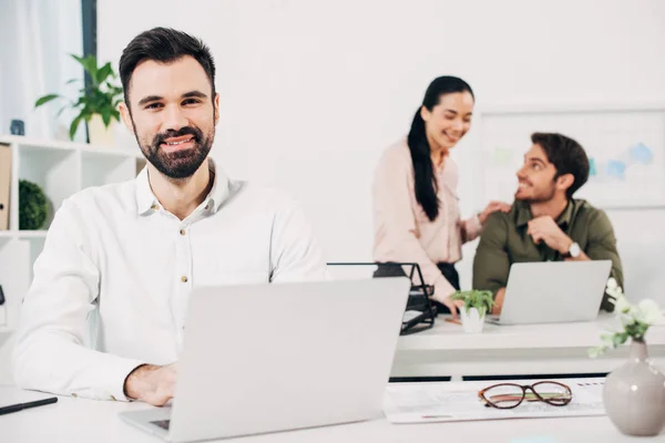 Selective focus of office manager with colleagues on background — Stock Photo