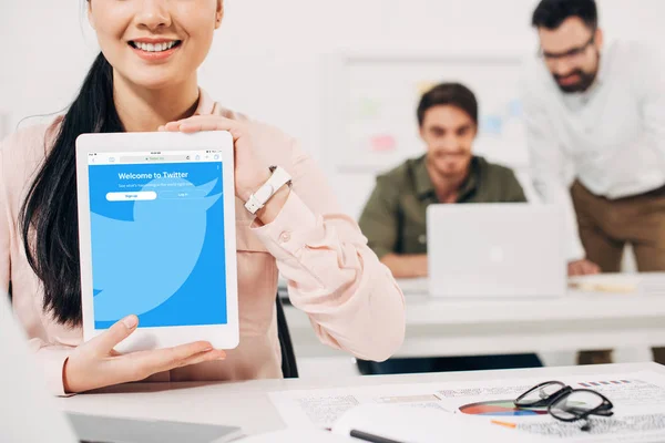 Ausgeschnittene Ansicht einer Frau, die digitales Tablet mit Twitter-App zeigt — Stockfoto