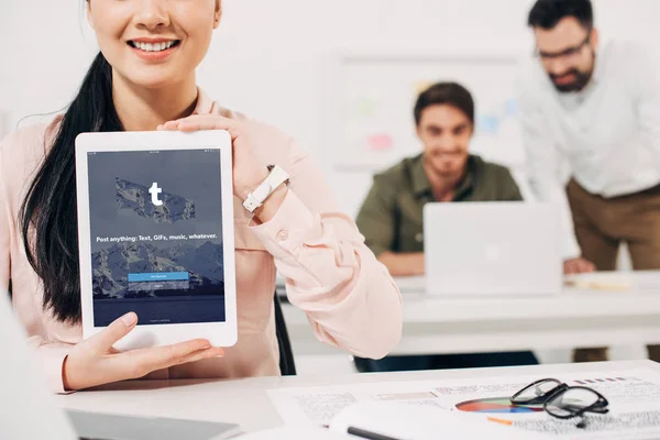 Cropped view of female manager showing digital tablet with tumblr app — Stock Photo