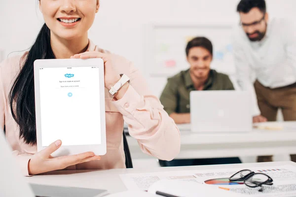 Vista recortada del gestor femenino sonriente mostrando tableta digital con aplicación skype - foto de stock