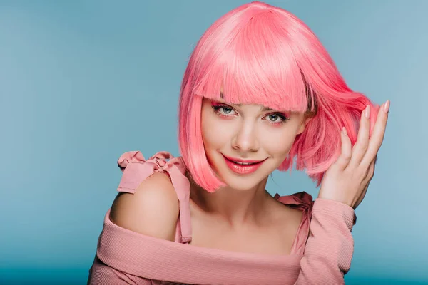 Fille sensuelle à la mode posant en perruque rose isolé sur bleu — Photo de stock