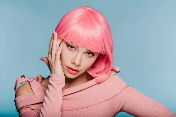 Atractiva joven posando en peluca rosa aislada en azul - foto de stock