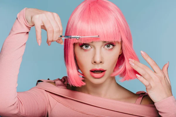 Scioccato ragazza elegante taglio capelli rosa con forbici isolato su blu — Foto stock