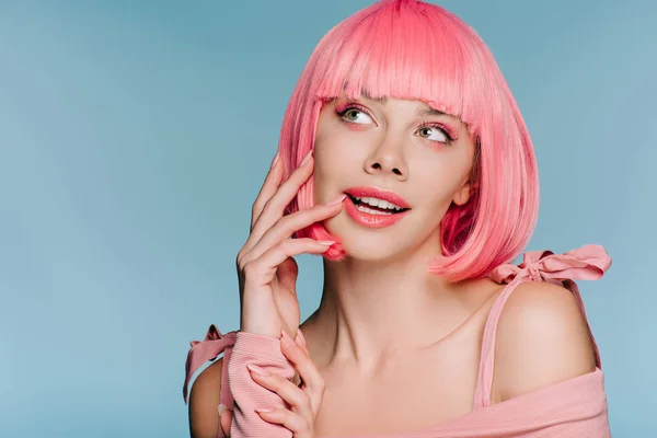 Bela menina sonhadora posando em peruca rosa isolado em azul — Fotografia de Stock