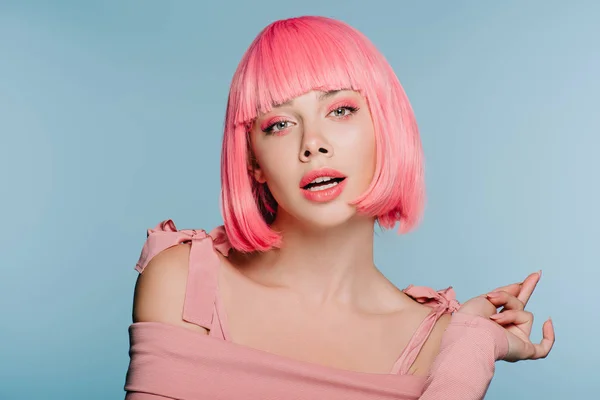 Atractiva chica sensual posando en peluca rosa aislado en azul - foto de stock