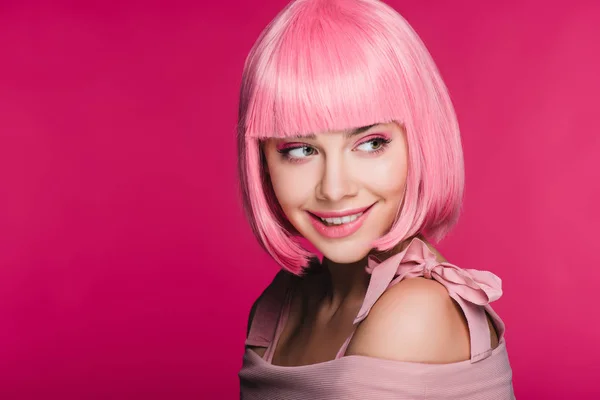Atractiva chica sensual en rosa peluca morder labio, aislado en rosa - foto de stock
