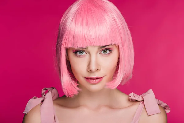 Attractive stylish young woman posing in pink wig, isolated on pink — Stock Photo