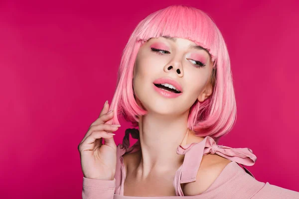 Sensual chica elegante posando en peluca rosa, aislado en rosa - foto de stock
