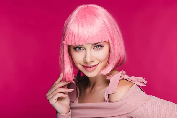 Schönes lächelndes Model posiert in rosa Perücke, isoliert auf rosa — Stockfoto