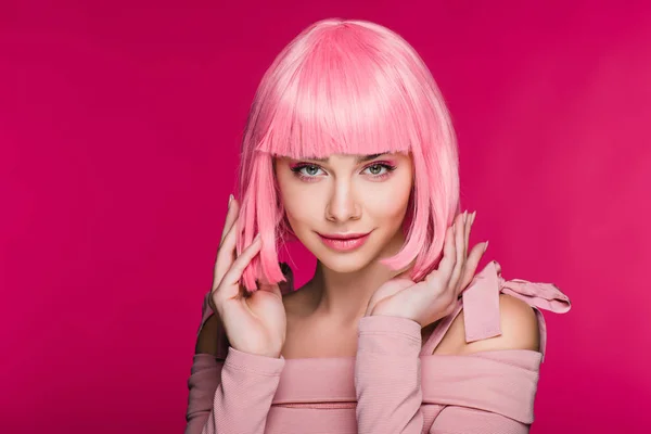 Красивая стильная модель, позирующая в розовом парике, изолированная на розовом — стоковое фото