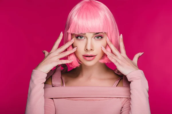 Menina elegante atraente gesticulando e posando em peruca rosa, isolado em rosa — Fotografia de Stock