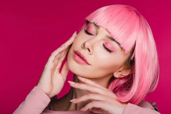 Tierna chica de peluca rosa posando con los ojos cerrados, aislado en rosa - foto de stock