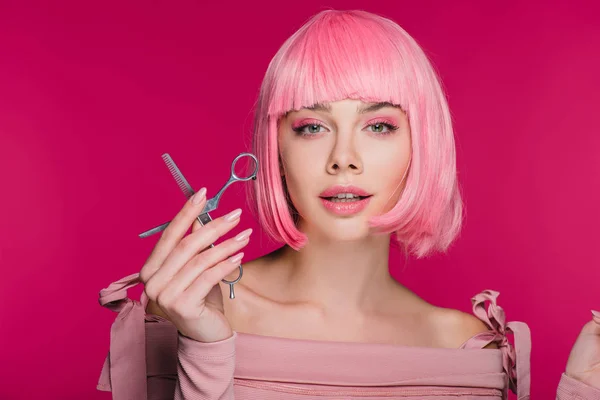 Bella ragazza alla moda in parrucca rosa con forbici isolate su rosa — Foto stock