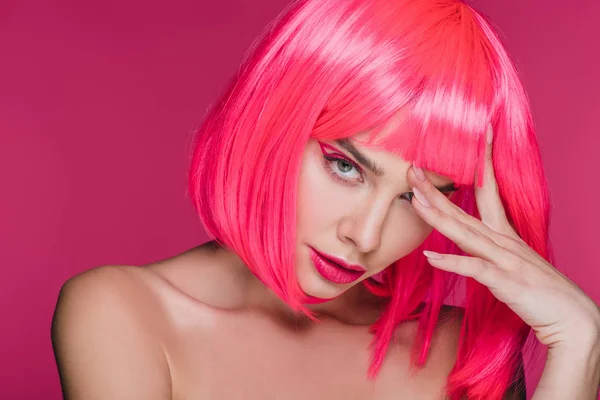 Привлекательная обнажённая женщина позирует в неоновом розовом парике, изолированная на розовом — стоковое фото