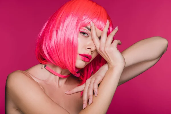 Atraente menina nua gesticulando e posando em néon peruca rosa, isolado em rosa — Fotografia de Stock