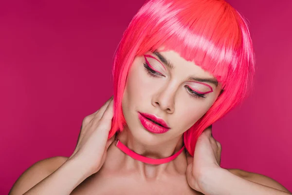 Chica de moda posando en peluca de neón rosa, aislado en rosa - foto de stock