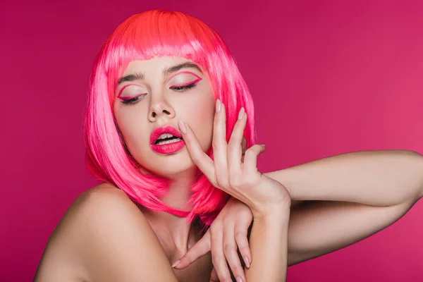 Modelo de glamour de moda haciendo gestos y posando en peluca rosa neón, aislado en rosa - foto de stock