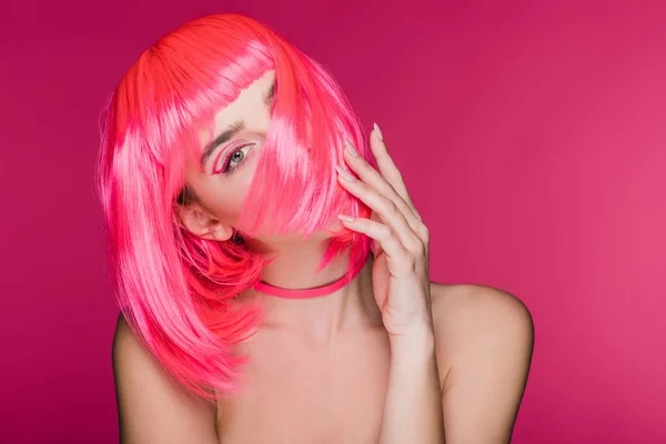 Bella modella elegante in posa in parrucca rosa neon, isolato su rosa — Foto stock