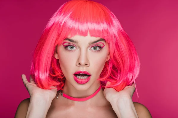 Shocked fashionable girl posing in neon pink wig, isolated on pink — Stock Photo