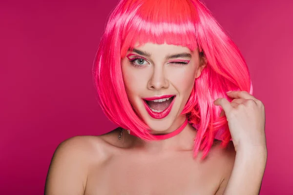 Возбужденный голая девушка подмигивая и позируя в неоновом розовый парик, изолированный на розовый — стоковое фото