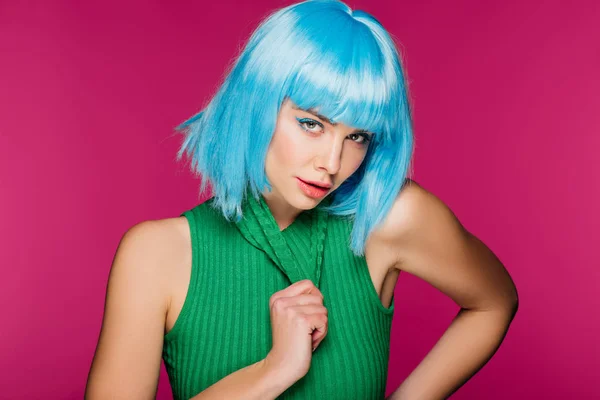 Привлекательная девушка позирует в голубом парике и зеленой водолазке, изолированная на розовом — стоковое фото