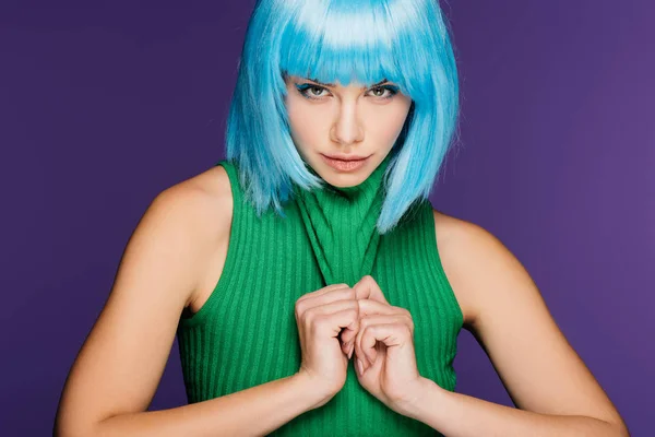 Menina atraente posando em peruca azul e gola alta verde, isolado em roxo — Fotografia de Stock