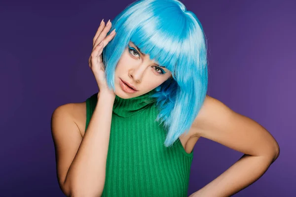 Bella giovane donna gesticolare e posa in parrucca blu, isolato su viola — Foto stock