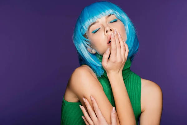 Chica sensual en peluca azul posando con los ojos cerrados, aislado en púrpura - foto de stock